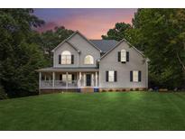 Charming two-story home with a spacious front yard and inviting covered porch at 25 Grange Ct, Sharpsburg, GA 30277