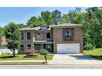 Charming two-story brick home with a manicured front yard and attached two-car garage at 4590 River Stone Trl, Douglasville, GA 30135