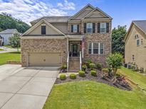 Beautiful two-story brick home with a well-manicured lawn and attached two-car garage at 1850 Overlook Springs Ln, Cumming, GA 30040