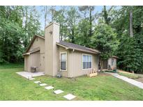 Charming home featuring a cozy patio, verdant lawn and delightful flower box, all nestled in a peaceful, wooded lot at 189 Timber Creek Ln, Marietta, GA 30060