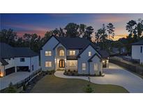 Stunning two-story home with landscaped front yard and well-lit driveway at dusk at 2631 Sardis Way, Buford, GA 30519