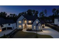 Elegant two-story home with modern architectural details and manicured front yard, showcasing sophisticated curb appeal at night at 2631 Sardis Way, Buford, GA 30519