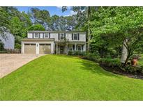 Charming two-story home with a well-manicured lawn, inviting front porch, and an attached two-car garage at 119 Laurel Mill Ct, Roswell, GA 30076