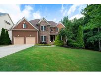 Charming brick two-story home boasts a well-manicured lawn, attached two-car garage, and mature landscaping at 685 Sienna Dr, Cumming, GA 30040