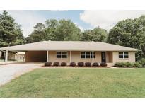 Charming single-story home with well-maintained lawn and covered parking at 8394 Banks Mill Rd, Douglasville, GA 30135