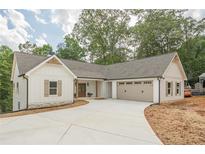 Charming single-Gathering home with white siding, stone accents, attached garage and concrete driveway at 912 Oak Dr, Woodstock, GA 30189