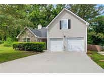 Charming home with a two-car garage, stone facade, manicured lawn, and lovely curb appeal at 468 Berkshire Place, Fairburn, GA 30213