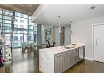 Modern kitchen with a marble waterfall island and stainless steel appliances at 845 Spring Street Northwest Nw St # 307, Atlanta, GA 30308