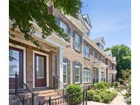 Brick townhouses with manicured landscaping, black iron railings, and covered entryways at 345 Alderwood Ln, Sandy Springs, GA 30328
