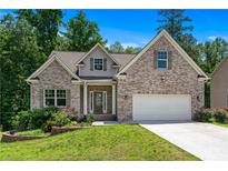Charming brick home featuring a manicured lawn, two-car garage, and inviting front entrance at 350 Paces Dr, Lithia Springs, GA 30122