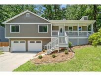 Charming home featuring a welcoming front porch, two-car garage and mature trees at 1080 Rackley Nw Way, Kennesaw, GA 30144