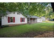 Cozy single-story home featuring red shutters and a charming front porch, nestled in a wooded lot at 11006 Clearwater Dr, Hampton, GA 30228