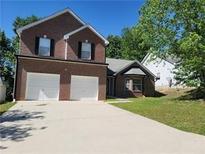 Two-story brick home with a two-car garage and a well-maintained front lawn at 1752 Spring Hill Cv, Lithonia, GA 30058