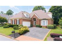 Charming brick home featuring manicured landscaping, a two-car garage, and a well-maintained front yard at 2324 Littlebrooke Ln, Dunwoody, GA 30338