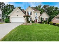Charming two-story home featuring a well-manicured lawn and attached two car garage at 310 Medridge Dr, Alpharetta, GA 30022