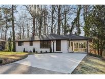 Charming single-story home with a modern painted brick facade and mature trees in a desirable neighborhood at 1120 Starline Se Dr, Smyrna, GA 30080