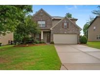 Charming two-story brick home featuring a well-manicured lawn and a two-car garage at 4650 Pleasant Woods Dr, Cumming, GA 30028