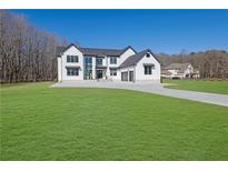 Stunning two-story modern farmhouse with black trim, white siding, and an expansive green lawn at 1604 Greendale Rd, Covington, GA 30014