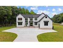Stunning two-story modern farmhouse with black trim and a large concrete driveway at 1604 Greendale Rd, Covington, GA 30014