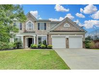 Charming brick two-story home with well-manicured lawn and attached two-car garage at 450 Hilingdon Way, Suwanee, GA 30024