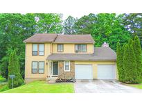 Charming two-story home featuring a two-car garage, stone accents, and a well-manicured front yard at 1012 Chapman Cir, Stone Mountain, GA 30088