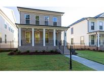 Charming brick home boasts a manicured lawn, covered front porch, and inviting curb appeal at 157 Basil St, Cumming, GA 30040
