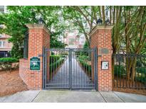 Secured entrance gate to residential complex, featuring brick pillars and lush greenery at 50 Biscayne Dr # 2106, Atlanta, GA 30309