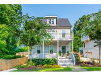 Charming two-story home with a gray exterior, inviting front porch, and beautifully landscaped front yard at 940 Longley Nw Ave, Atlanta, GA 30318