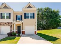 Charming townhome featuring a well-manicured lawn and a private garage, complete with classic architectural accents at 5525 Sable Way, Atlanta, GA 30349