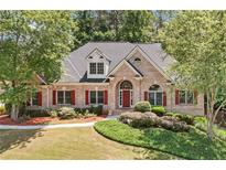 Charming brick home with well-maintained landscaping, red shutters, and inviting curb appeal at 997 Thousand Oaks Nw Bnd, Kennesaw, GA 30152
