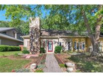 Charming single-story home featuring a stone chimney, well-kept lawn, and a vibrant red front door at 1025 Whitfield Ct, Smyrna, GA 30080