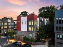 Modern townhome exterior featuring brick and metal accents with ample windows and a well-lit facade at dusk at 395 Pratt Drive Se # No 802, Atlanta, GA 30315
