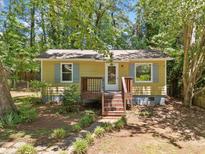 Charming single-story home with a quaint front porch and walkway surrounded by lush greenery at 4614 Ridge Dr, Pine Lake, GA 30072