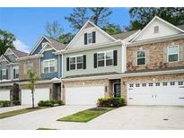 Charming exterior view of new townhomes featuring stone accents and attached garages at 2140 Ravencliff Dr, Austell, GA 30168