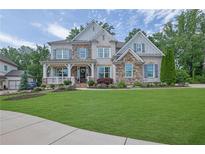 Charming two-story home featuring a beautifully landscaped yard and inviting front porch at 3330 Riverwalk Way, Cumming, GA 30040