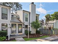 Charming two-story townhouse with grey siding, black trim, a chimney, and a well-manicured front yard at 1027 Riverbend Club Se Dr, Atlanta, GA 30339