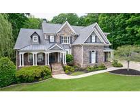 Charming two-story home with stone and brick exterior, manicured lawn, and inviting front porch at 2101 Hunters Green Dr, Lawrenceville, GA 30043
