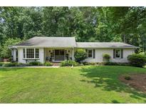 Charming single-story home features a well-manicured lawn and mature trees that provide shade and privacy at 290 Dania Dr, Alpharetta, GA 30009