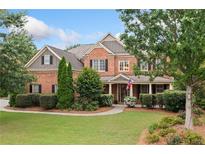 Charming two-story brick home with a well-manicured lawn and inviting front porch at 910 Ovalene Sw Ln, Marietta, GA 30064