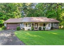 Charming single-story home with stone accents, a cozy front porch, and a well-maintained front yard at 1757 Mystery Sw Cir, Conyers, GA 30094