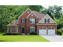 Beautiful two-story brick home featuring a well-manicured lawn and a two-car garage at 2940 Saddlebrook Glen Dr, Cumming, GA 30041