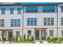 Charming townhome exterior with light brick, neutral siding, and professional landscaping at 3693 Allegretto Cir, Atlanta, GA 30339