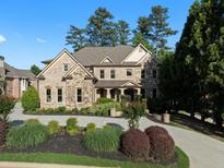 Beautiful two-story home featuring stone and brick with a manicured lawn and circular driveway at 8805 Marion Dr, Duluth, GA 30097