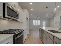 Modern kitchen featuring stainless steel appliances, white cabinets, and a large island with countertop at 3348 Cranston Ln, Kennesaw, GA 30144