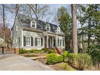 Charming home showcasing manicured landscaping, brick walkway, and gray siding beneath a shingled roof at 735 Longwood Nw Dr, Atlanta, GA 30305