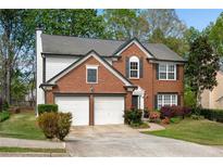 Charming brick two-story home featuring an attached two-car garage and manicured front lawn at 3925 Tugaloo River Dr, Duluth, GA 30097