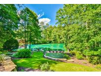 Beautiful backyard oasis with putting green, lake and wooded views, perfect for relaxation and outdoor enjoyment at 5675 Habersham Vly, Suwanee, GA 30024