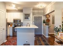 Modern kitchen features stainless steel appliances, white cabinets, backsplash and breakfast bar at 10 Perimeter Summit Ne Blvd # 4315, Brookhaven, GA 30319