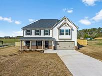 Two-story home with covered entry, gray roof, two-car garage, and neutral siding at 1707 Bouquet Way, Mcdonough, GA 30253