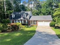 Charming two-story home with a well-manicured lawn, mature trees, and a two-car garage at 626 Cheatham Sw Dr, Marietta, GA 30064